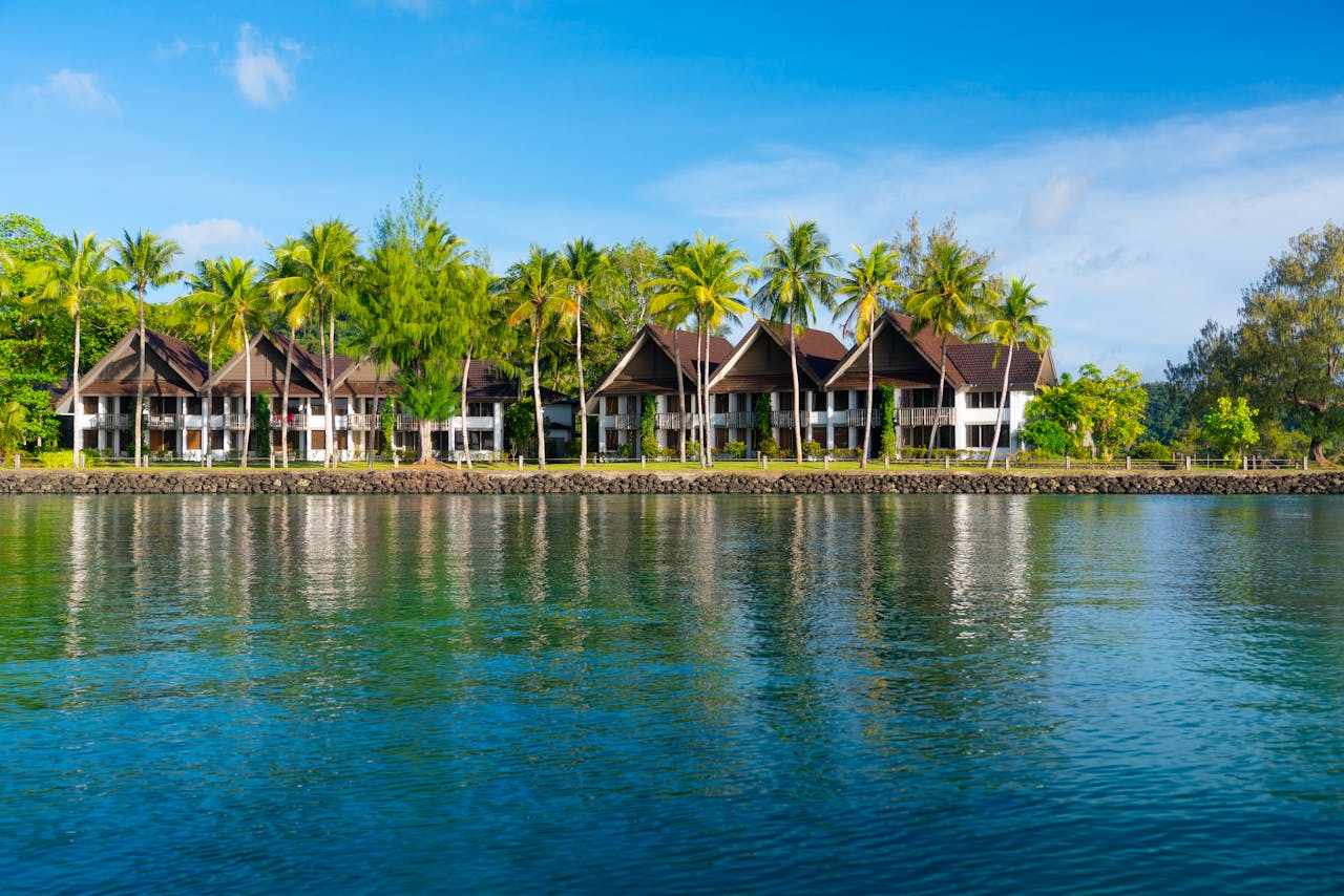 Scenic view of a tropical resort with palm trees reflecting in the calm water, perfect summer getaway.