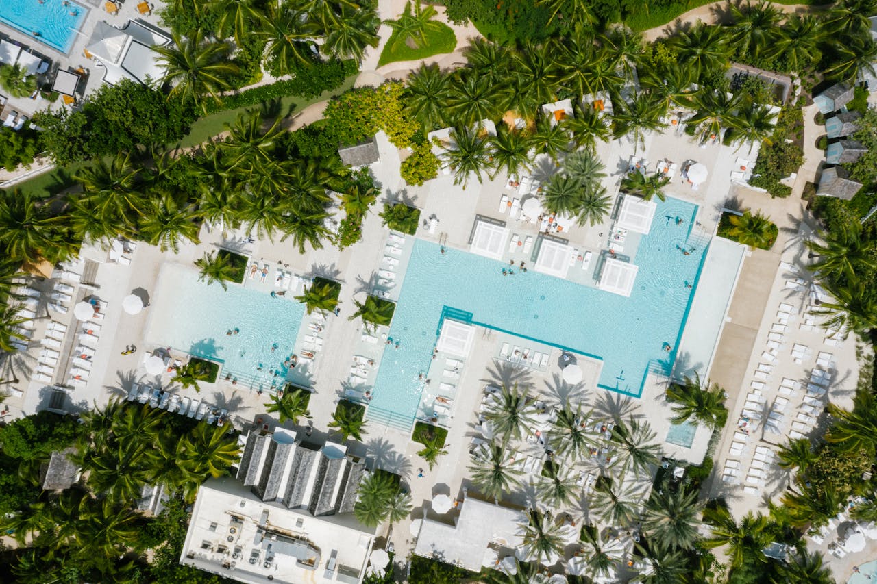 A stunning aerial view of a luxurious resort featuring expansive swimming pools and lush greenery in the Bahamas.